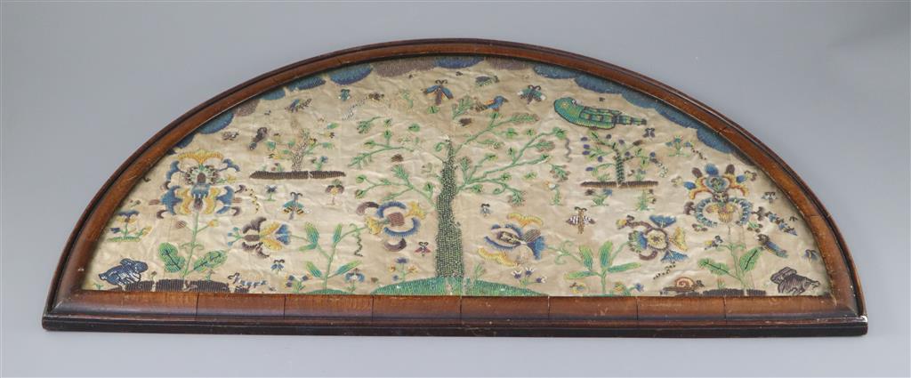 A late 17th century silk and bead work arched panel, width 22.5in. height 11.75in.